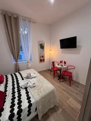a bedroom with a bed and a table with chairs at La Rubis in Narbonne