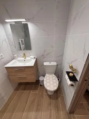 a bathroom with a toilet and a sink and a mirror at La Rubis in Narbonne