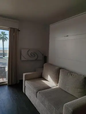 a living room with a couch and a window at Studio SAM - Face à la Mer in Port-la-Nouvelle