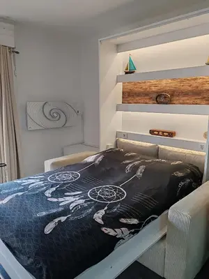 a bedroom with a bed with a painting on it at Studio SAM - Face à la Mer in Port-la-Nouvelle