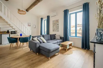 a living room with a couch and a table at Le Chenal - Appartement Duplex proche des halles in Narbonne