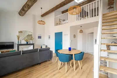 a living room with a couch and a table at Le Chenal - Appartement Duplex proche des halles in Narbonne