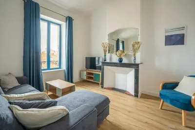 a living room with a couch and a fireplace at Le Chenal - Appartement Duplex proche des halles in Narbonne