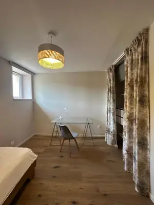 a bedroom with a desk and a bed and a table at La remise d'Edouard in Saint-Papoul