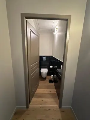a bathroom with a toilet and a door at La remise d'Edouard in Saint-Papoul