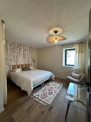 a bedroom with a bed and a couch and a window at La remise d'Edouard in Saint-Papoul