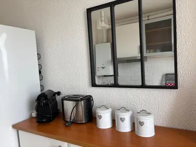 a counter top with a mirror and a toaster and a sink at La Sentinelle - Vue Cité in Carcassonne