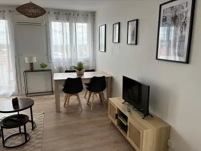 a living room with a television and a table and chairs at La Sentinelle - Vue Cité in Carcassonne