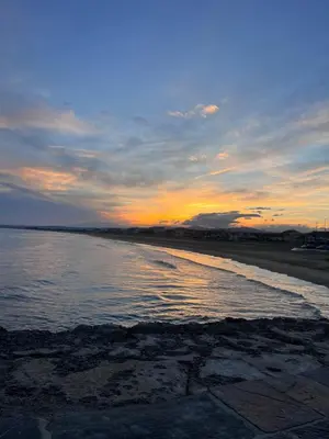 a sunset on the beach with the water at Appartement dans le village à port la nouvelle in Port-la-Nouvelle