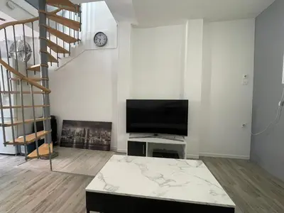 a living room with a flat screen tv on a wall at Appartement dans le village à port la nouvelle in Port-la-Nouvelle
