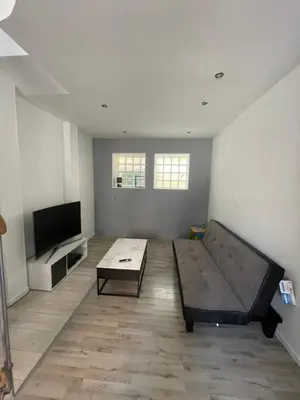 a living room with a couch and a tv at Appartement dans le village à port la nouvelle in Port-la-Nouvelle