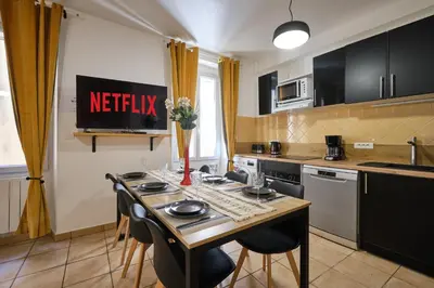 a kitchen with a table and chairs in a kitchen at Sunny Pearl - Spacieux Appartement Climatisé au Centre ville in Narbonne