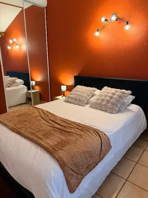 a bedroom with a large bed with a large mirror at Sunny Pearl - Spacieux Appartement Climatisé au Centre ville in Narbonne