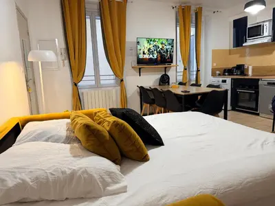 a bedroom with a white bed with yellow pillows on it at Sunny Pearl - Spacieux Appartement Climatisé au Centre ville in Narbonne