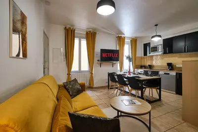 a living room with a yellow couch and a kitchen at Sunny Pearl - Spacieux Appartement Climatisé au Centre ville in Narbonne
