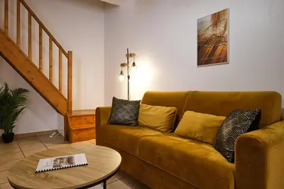 a living room with a couch and a table at Sunny Pearl - Spacieux Appartement Climatisé au Centre ville in Narbonne