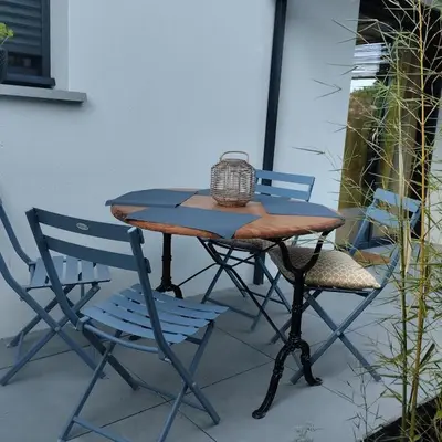 a picnic table and two chairs on a patio at Le Logis de la Voie Verte in Saint-Amadou