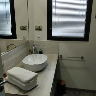 a bathroom with a sink with towels on a counter at Le Logis de la Voie Verte in Saint-Amadou