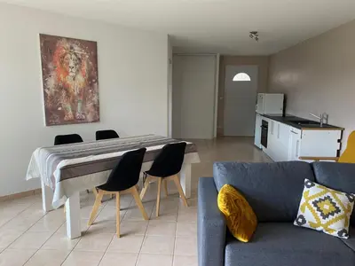 a living room with a couch and a table and chairs at Dépendance paisible in Ventenac-Cabardès
