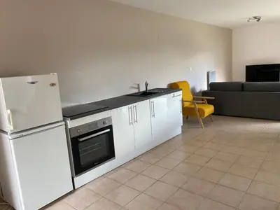 a kitchen with a white refrigerator and a couch at Dépendance paisible in Ventenac-Cabardès