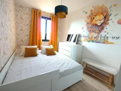 a bedroom with a white bed with orange curtains at La maison des moments in Carcassonne