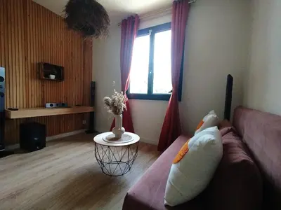 a living room with a couch and a window at La maison des moments in Carcassonne