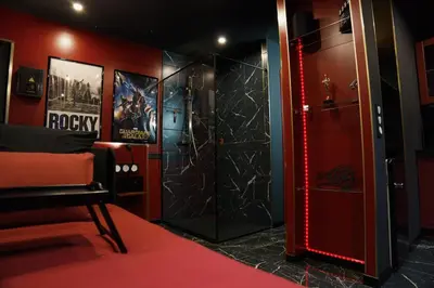 a room with a shower with a red wall at Studio Cinéma privé Centre ville & King size in Narbonne