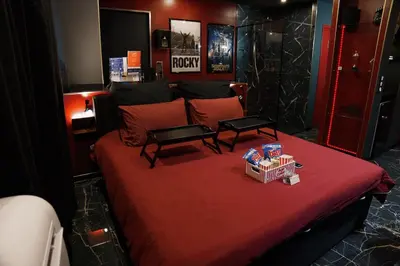 a bedroom with a red bed with two tables on it at Studio Cinéma privé Centre ville & King size in Narbonne