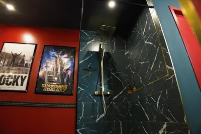 a bathroom with a black marble wall with a movie poster at Studio Cinéma privé Centre ville & King size in Narbonne