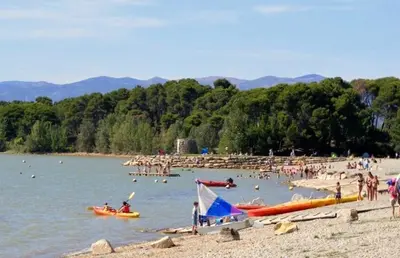 a group of people on the beach at a lake at Maison dans le sud au calme avec extérieur in Ferrals-lès-Corbières