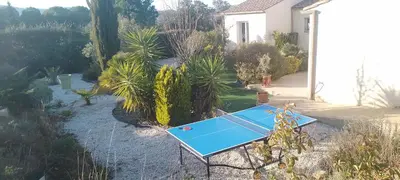 a ping pong table in a yard with a house at Maison dans le sud au calme avec extérieur in Ferrals-lès-Corbières