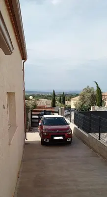 a red car parked in a parking lot at Maison dans le sud au calme avec extérieur in Ferrals-lès-Corbières