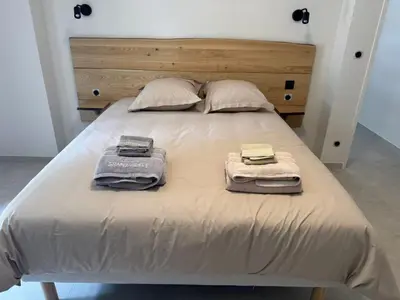 a bed with two towels and two pillows on it at Villa Les Charmes in Narbonne