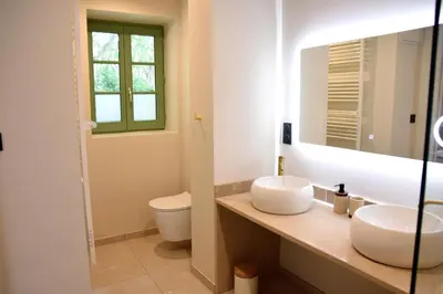 a bathroom with two sinks and a toilet at Villa Les Charmes in Narbonne