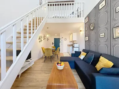 a living room with a blue couch and a table at Le Datrio - Appartement proche des halles - Wifi et climatisation in Narbonne