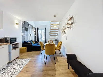 a kitchen and living room with a table and chairs at Le Datrio - Appartement proche des halles - Wifi et climatisation in Narbonne