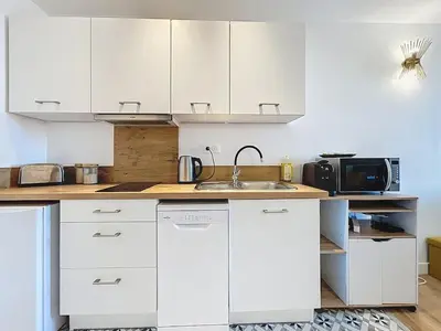 a white kitchen with a sink and a microwave at Le Datrio - Appartement proche des halles - Wifi et climatisation in Narbonne