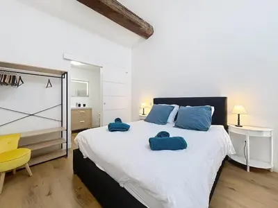 a bedroom with a large bed with two towels on it at Le Datrio - Appartement proche des halles - Wifi et climatisation in Narbonne