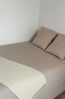 a white bed with two pillows on top of it at Appartement T2 in Port-la-Nouvelle