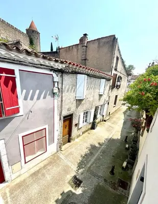 an empty alley with two buildings and a window at La Loge des Remparts in Carcassonne