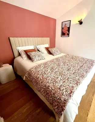 a bedroom with a large bed in a pink wall at La Loge des Remparts in Carcassonne