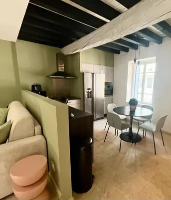 a living room with a table and a kitchen at La Loge des Remparts in Carcassonne