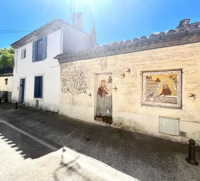a building with a mural on the side of it at La Loge des Remparts in Carcassonne
