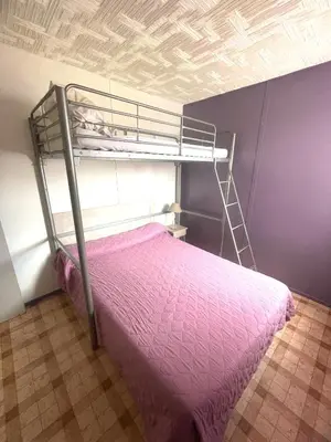 a bedroom with a bunk bed with pink sheets at Chalet climatisé 5 personnes Gruissan plage in Gruissan
