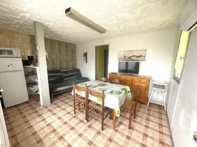 a kitchen and dining room with a table and a television at Chalet climatisé 5 personnes Gruissan plage in Gruissan