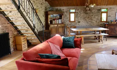 a living room with a red couch and a staircase at La Terrasse aux citronniers in Saint-Vincent