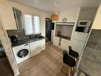 a kitchen with a washing machine and two chairs at Appartement centre-ville Narbonne 5 personnes, climatisé, 2 chambres in Narbonne