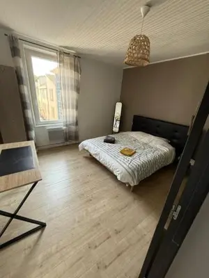 a bedroom with a bed and a large window at Appartement centre-ville Narbonne 5 personnes, climatisé, 2 chambres in Narbonne
