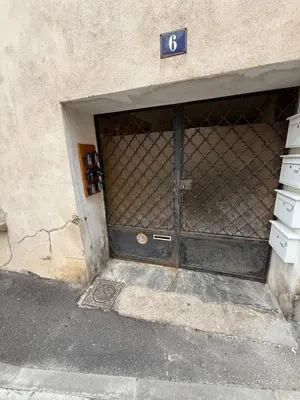 a metal garage door with a sign on it at Appartement centre-ville Narbonne 5 personnes, climatisé, 2 chambres in Narbonne