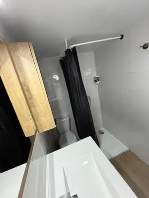 a bathroom with a black shower curtain and a toilet at Appartement centre-ville Narbonne 5 personnes, climatisé, 2 chambres in Narbonne